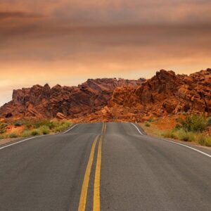 Image of a road heading into the mountains at sunrise